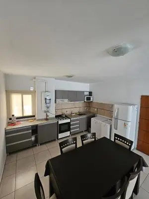 a kitchen with a black table and chairs in it at Apartamento Esquiu C in Villa Carlos Paz
