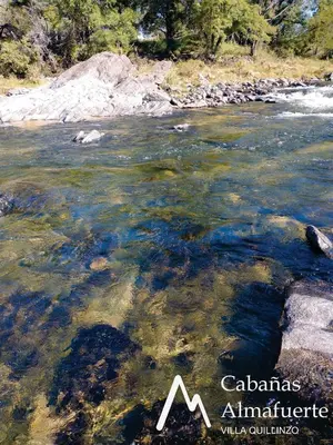 a river with rocks in the water at Cabañas Almafuerte in Villa Quillinzo
