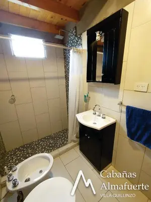 a bathroom with a sink and a shower and a toilet at Cabañas Almafuerte in Villa Quillinzo