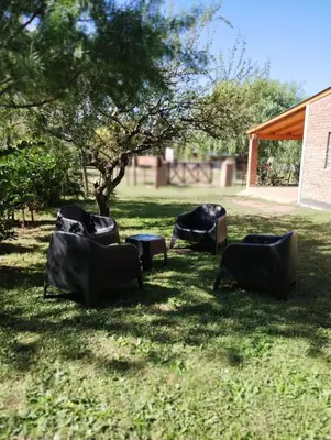 a group of chairs sitting in the grass at Cabañas Almafuerte in Villa Quillinzo