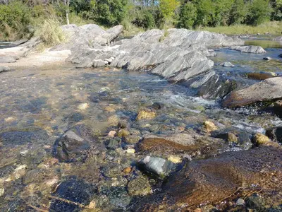 a river filled with rocks and water at Cabañas Almafuerte in Villa Quillinzo