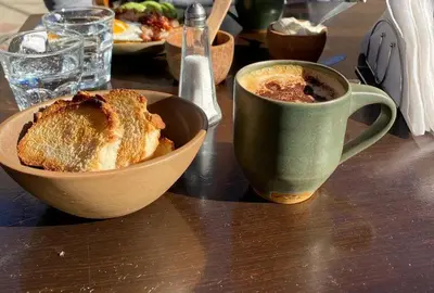 a table with a bowl of bread and a cup of coffee at Architerra in San Javier