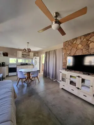 a living room with a table and a ceiling fan at SOLSALI Cabaña moderna in San Javier