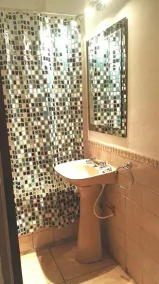a bathroom with a sink and a shower with a mirror at Amplio y Centrico in Cordoba