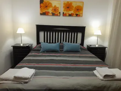 a bedroom with a large bed with blue pillows at Amplio y Centrico in Cordoba