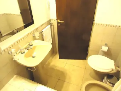 a bathroom with a sink and a toilet and a mirror at Amplio y Centrico in Cordoba