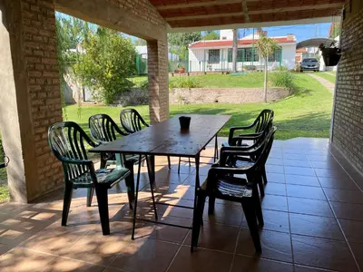 a wooden table and chairs on a patio at La Casa de Tita in Villa Carlos Paz