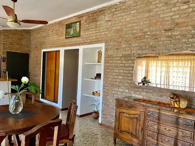 a kitchen with a table and a brick wall at La Casa de Tita in Villa Carlos Paz