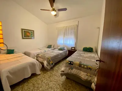 a bedroom with two beds and a ceiling fan at La Casa de Tita in Villa Carlos Paz
