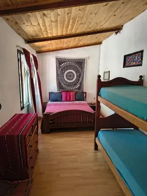 a room with two beds in a room with wooden ceilings at La Casa De La Gruta in Mina Clavero