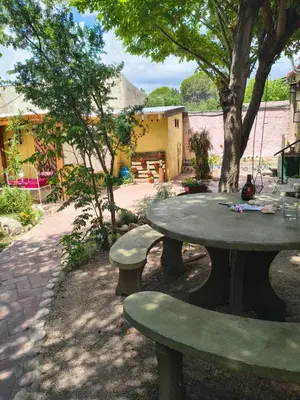 a picnic table in a yard with a tree at La Casa De La Gruta in Mina Clavero