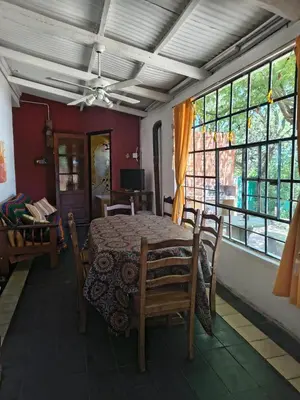 a dining room with a table and chairs and windows at La Casa De La Gruta in Mina Clavero