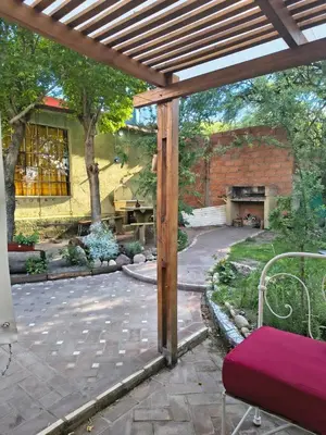 a patio with a wooden pergola and a brick building at La Casa De La Gruta in Mina Clavero