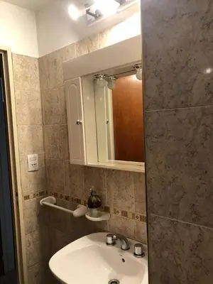 a bathroom with a sink and a mirror at Departamento Alberdi Completo con Cochera in Cordoba