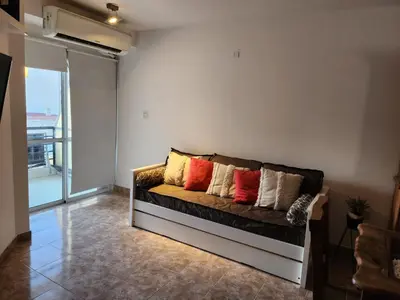 a couch with pillows on it in a living room at Departamento Alberdi Completo con Cochera in Cordoba