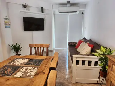 a living room with a wooden table and a couch at Departamento Alberdi Completo con Cochera in Cordoba