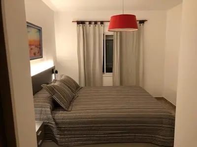 a bedroom with a bed with a red lamp at Departamento Alberdi Completo con Cochera in Cordoba