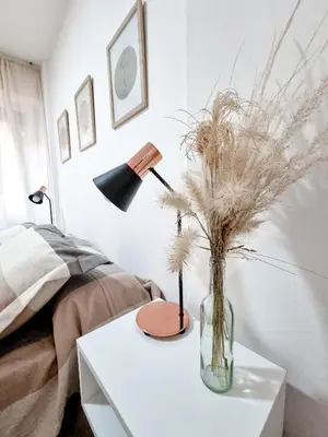 a table with a vase with dry grass on it at DPTO 3 CUADRAS SANATORIO ALLENDE - NVA CBA in Cordoba