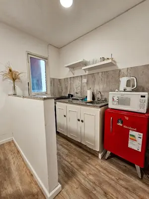 a kitchen with white cabinets and a red appliance at DPTO 3 CUADRAS SANATORIO ALLENDE - NVA CBA in Cordoba