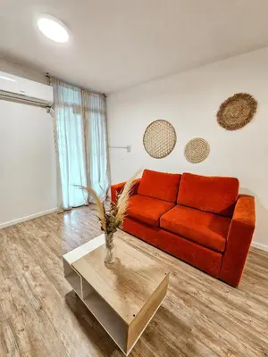 a living room with a red couch and a table at DPTO 3 CUADRAS SANATORIO ALLENDE - NVA CBA in Cordoba