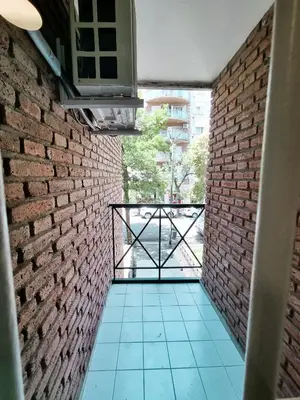 a room with a brick wall and a balcony at DPTO 3 CUADRAS SANATORIO ALLENDE - NVA CBA in Cordoba
