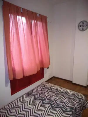 a bed in a room with a pink window at Departamento Alberdi Little in Cordoba