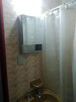a bathroom with a sink and a mirror and a shower at Departamento Alberdi Little in Cordoba