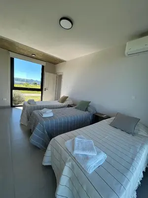 two beds in a room with a large window at Casa Puerto del Aguila - Potrero de Garay in Potrero de Garay