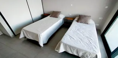 two beds in a small room with white sheets at Casa Puerto del Aguila - Potrero de Garay in Potrero de Garay