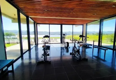 a gym with exercise bikes in a room with windows at Casa Puerto del Aguila - Potrero de Garay in Potrero de Garay