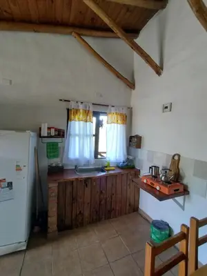 a kitchen with a sink and a refrigerator at Cabañas de montaña 