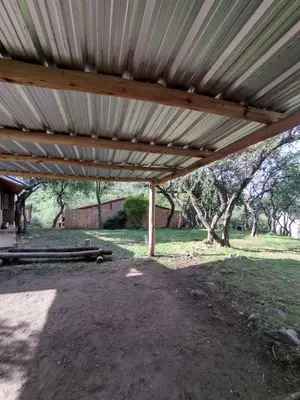 a wooden pergola with a picnic table under it at Cabañas de montaña 