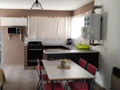 a kitchen with a table and chairs and a kitchen with a stove at Los Ceibos dpto para 4 personas in Estancia Vieja