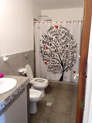 a bathroom with a shower curtain with a tree on it at Los Ceibos dpto para 4 personas in Estancia Vieja