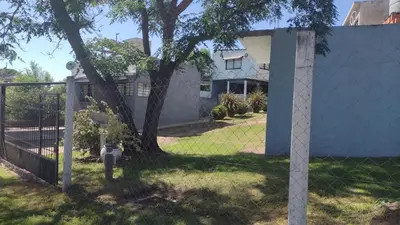 a fence with a fire hydrant in front of a house at Los Ceibos dpto para 4 personas in Estancia Vieja