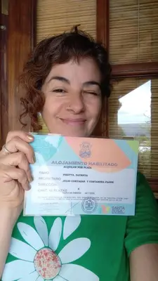 a woman is holding up a box with a gift at Luna en Acuario Hospedaje in Santa Rosa de Calamuchita