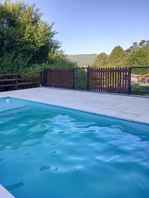 a pool with blue water in front of a fence at Luna en Acuario Hospedaje in Santa Rosa de Calamuchita