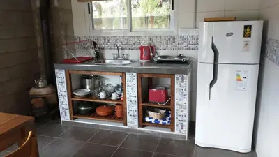 a kitchen with a white refrigerator and a sink at Luna en Acuario Hospedaje in Santa Rosa de Calamuchita