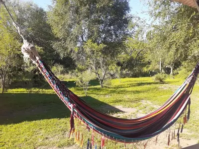 a hammock in a park with a field at Las Martinetas in Santa Rosa de Calamuchita