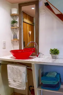 a bathroom with a red sink and a mirror at Las Martinetas in Santa Rosa de Calamuchita