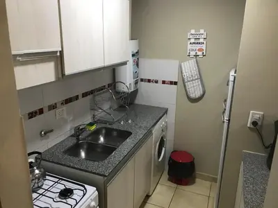 a small kitchen with a sink and a stove at Elegante Departamento en Alta Córdoba in Cordoba