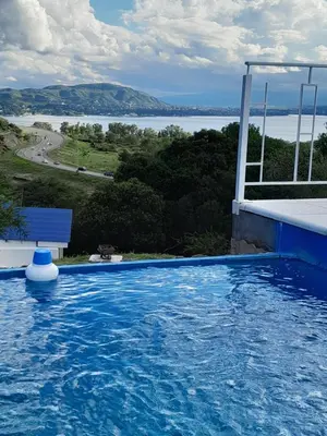 a swimming pool with a view of the water at Cabaña de Montaña, pileta infinito, wifi, Vista directa al Lago en San Roque a mints de Carlos Paz in Cordoba