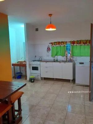 a kitchen with white cabinets and a green curtain at Cabaña de Montaña, pileta infinito, wifi, Vista directa al Lago en San Roque a mints de Carlos Paz in Cordoba