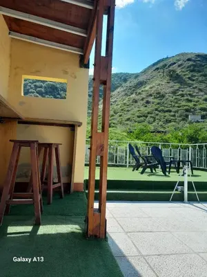 a house with two chairs and a table on a balcony at Cabaña de Montaña, pileta infinito, wifi, Vista directa al Lago en San Roque a mints de Carlos Paz in Cordoba