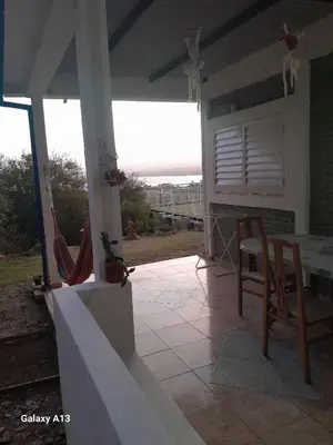 a patio with a table and chairs on a house at Cabaña de Montaña, pileta infinito, wifi, Vista directa al Lago en San Roque a mints de Carlos Paz in Cordoba