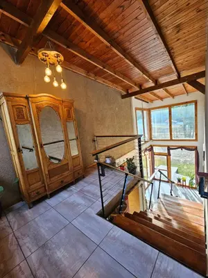 a living room with a staircase and a wooden ceiling at La Reina Hotel in Santa Rosa de Calamuchita