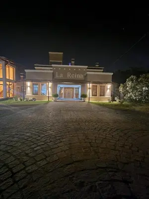 a large building with a lit up front at night at La Reina Hotel in Santa Rosa de Calamuchita