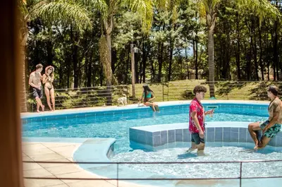 a group of people playing in a swimming pool at La Reina Hotel in Santa Rosa de Calamuchita