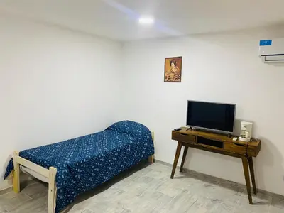 a bedroom with a bed and a tv on a table at Complejo Las Violetas in Merlo