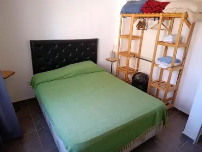 a bedroom with a bed with a green bedspread at Departamentos Talamuchita in Santa Rosa de Calamuchita